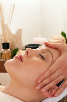 Beautiful woman enjoying a face massage competently carried out in a spa