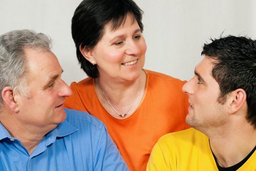 Family - mother, father, and adult son looking at each other