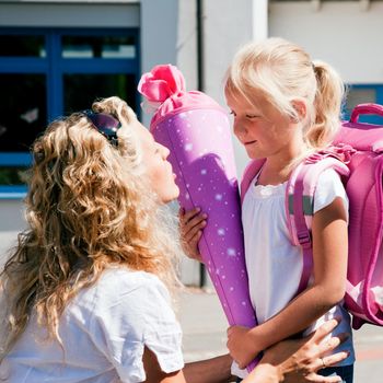 Mother taking her daughter to school, saying her goodbye for the day