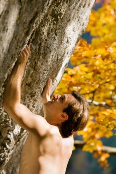 Free solo climber inspecting the rock for a grip or crack to drag in