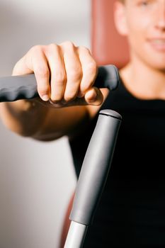 Man doing fitness training in the Gym on an exercising machine