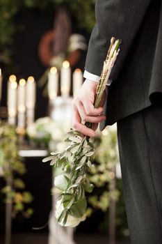 Religion, death and dolor - man at funeral with white rose mourning the dead