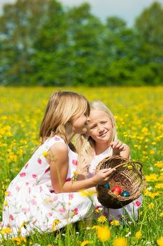 Children on an Easter Egg hunt on a meadow in spring