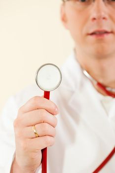 Medical doctor with stethoscope, focus is on the worktool