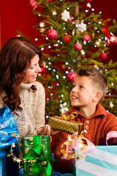 Christmas - happy family (mother with sun) with gifts on Xmas Eve