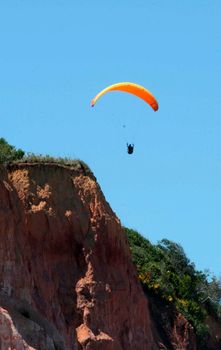 porto seguro, bahia / brazil - february 7, 2008: Paragliding pilot is seen during flight at Taipe beach in the Trancoso district of Porto Seguro.