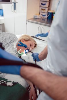 Doctor holding endoscope during gastroscopy in hand while patient is under narcosis