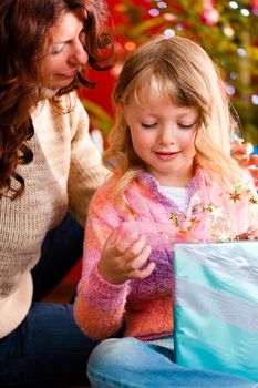 Christmas - happy family (mother with daughter) with gifts on Xmas Eve