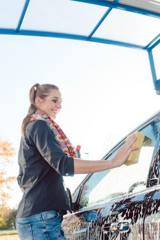 Woman foaming her car with sponge