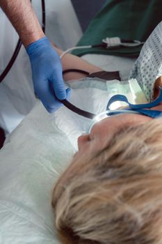 Doctor inserting camera of endoscope during gastroscopy in mouth of patient