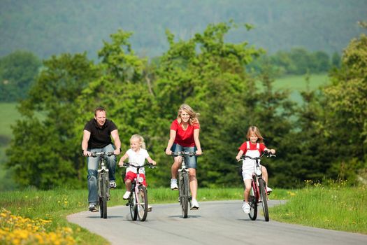 Family with children having a weekend excursion on their bikes on a summer day