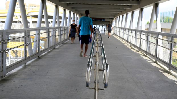 salvador, bahia, brazil - january 8, 2021: people are seen passing by a handrail on a pedestrian walkway in the city of Salvador. The site is a source of contamination from the corona virus.