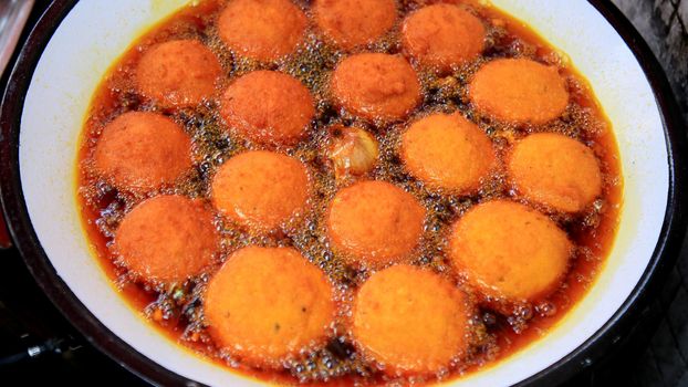 salvador, bahia, brazil - january 8, 2021: acaraje during frying in a pan with palm oil, in downtown Salvador.