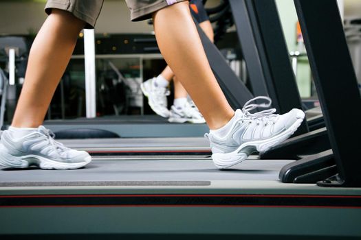Young woman walks on treadmill