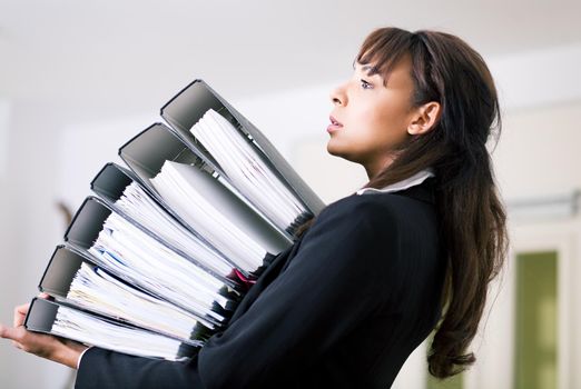 Female office worker carrying a stack of files