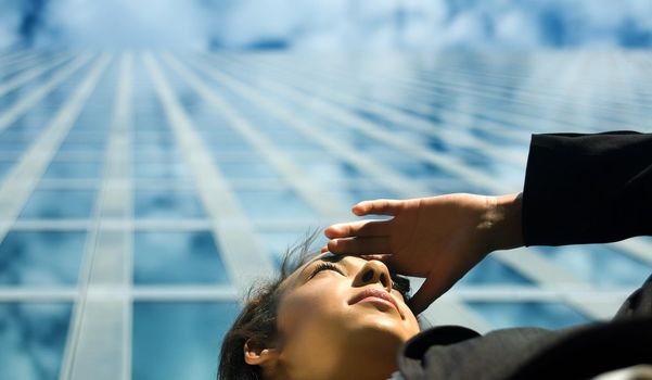 A young professional woman looking far away in front of a modern office building, presumably at new career options