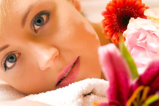 Girl with flowers in a spa situation feeling visibly good