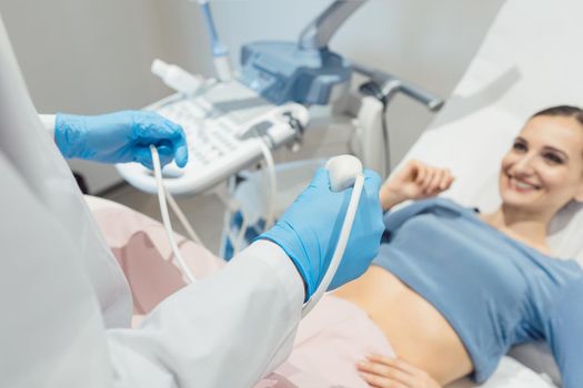 Gynecologist attempting ultrasonic examination of patient woman