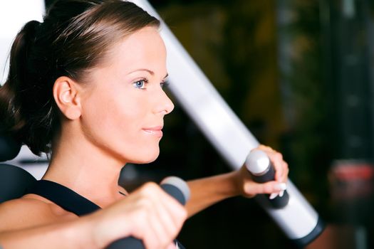 Beautiful girl working out in a gym (face in profile)