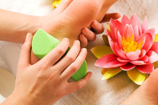 Woman enjoys peeling in the beauty studio(closeup on feet)