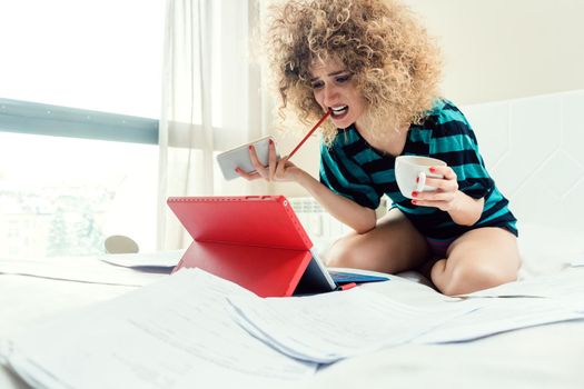 Telecommuting woman being desperate having no clue working on her bed