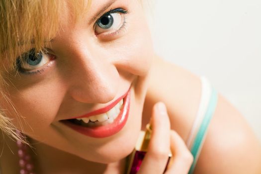 Beautiful woman using perfume and enjoying it visibly