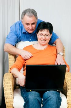 Senior couple surfing the internet using a laptop computer