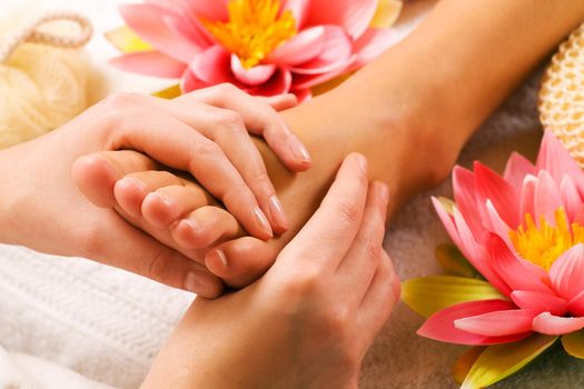 Woman enjoying a feet massage in a spa setting (close up on feet)