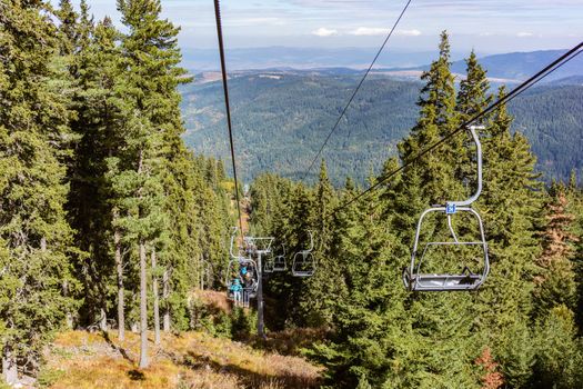 Family in chair lift going up mountain for a hike