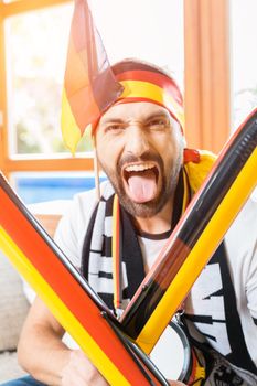 Young man cheering for the German soccer team on TV