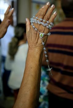 salvador, bahia / brazil - november 8, 2019: Hand holding religious rosary is seen during mass at Bonfim Church in Salvador city.


