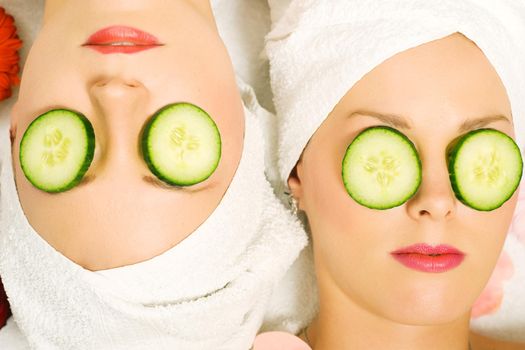 Girls in a beauty treatment with cucumber slices