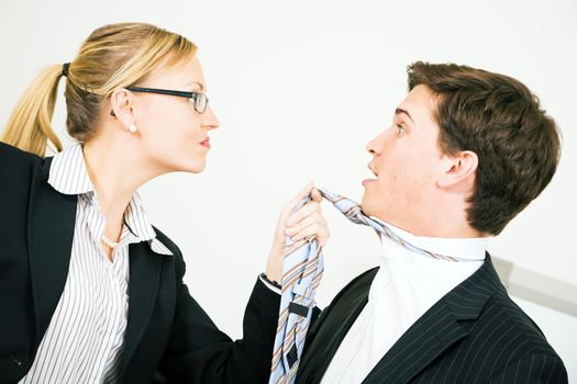 Businesswoman grabbing her colleague at his tie