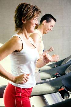 Woman on the treadmill, having a short break and looking around