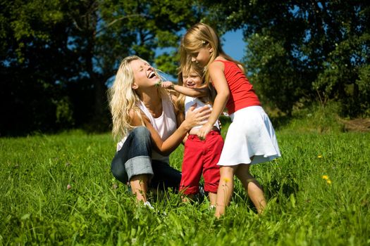 Family (mother with two kids) on a sunlit meadow