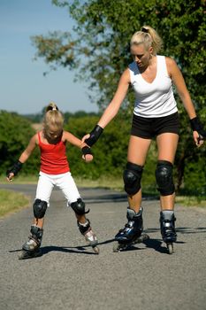 Mother helping her daughter learning to skate