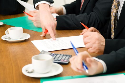 Business Team discussing documents, presumably contracts or numbers, closeup