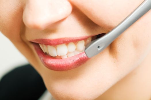 Close-up (mouth) of a friendly female call center operator