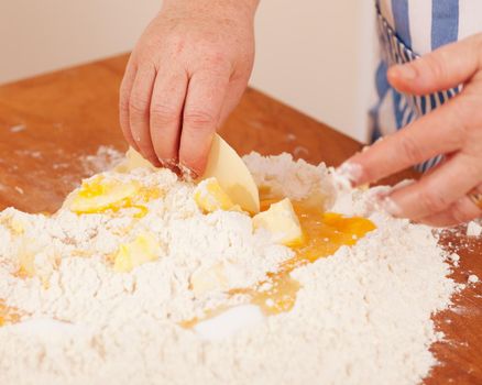 Baking biscuits, woman putting butter in the flour