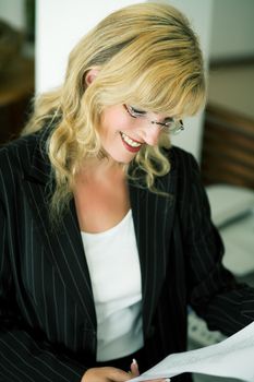 A woman in business dress reading documents that contain good news