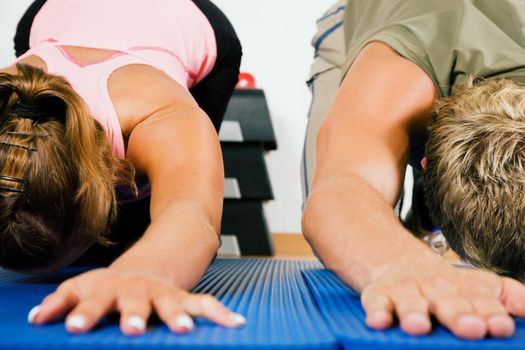 Couple doing stretching and gymnastics on a gym mat