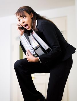 Female office worker being barely able to do all assigned tasks simultaneously