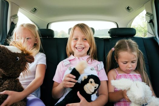 Family with three kids in a car