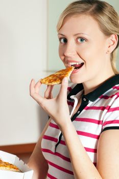 Woman biting in a slice of yummy pizza