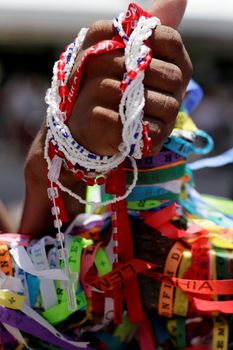 salvador, bahia / brazil - january 15, 2015: hand holds Senhor do Bonfim ribbon during traditional washing of Bonfim church stairs in the city of Salvador.