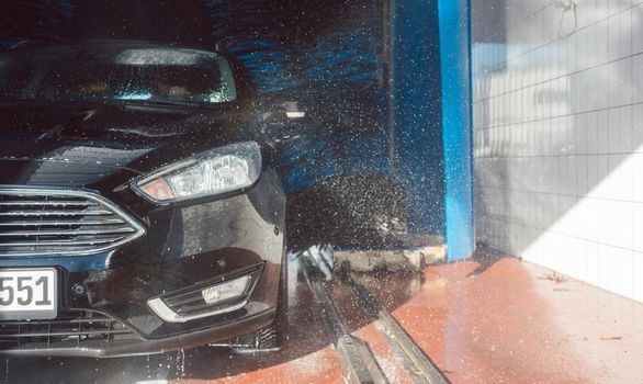 Brush turning in car wash with vehicle in it