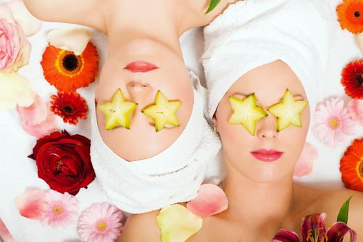 Girls in a beauty treatment with star fruit slices on their eyes