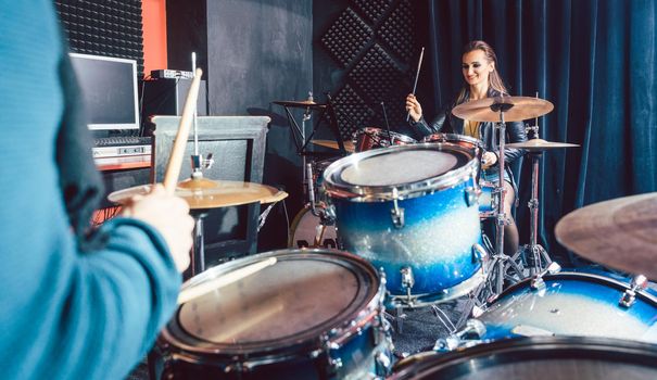 Woman receiving drum lessons from her music teacher in school