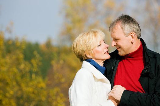 Mature couple having a walk holding each other tight still in love with each other