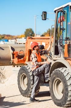 Wheel loader with tip-up bucket on construction site in action